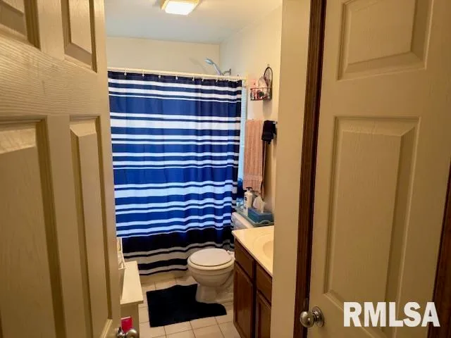 a bathroom with a toilet and a shower curtain