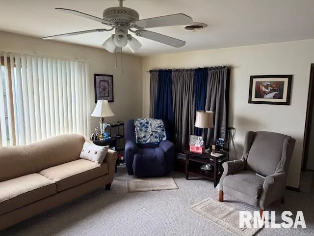 a living room with furniture and a ceiling fan
