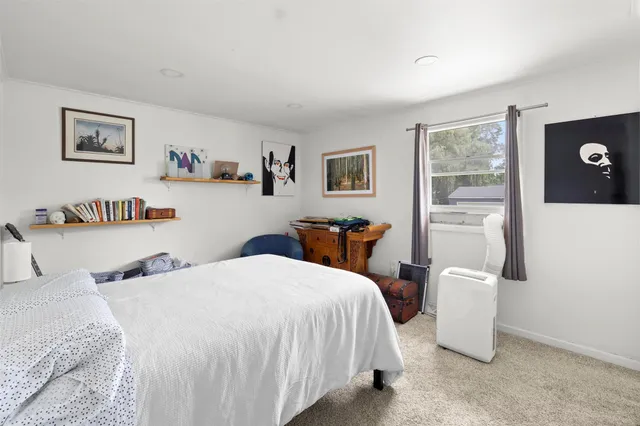 a bedroom with a bed and a large mirror on a dresser