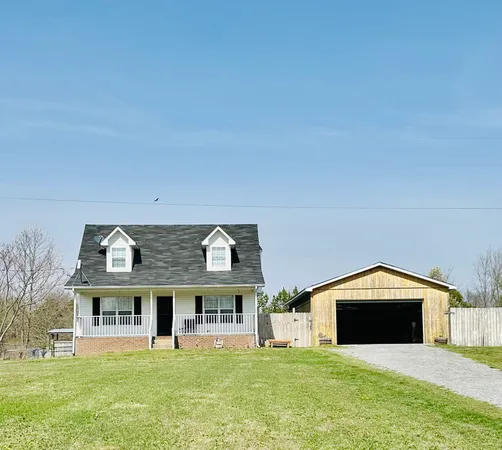 a view of a big house with a big yard and large trees