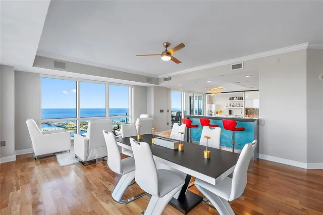 a living room with furniture flowers and a floor to ceiling window