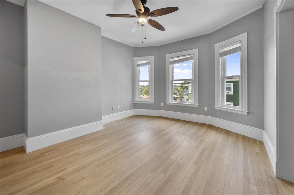43 Robinson Street, Unit 3 Boston, MA 02122 - Photo 14 of 42 an empty room with wooden floor chandelier fan and windows