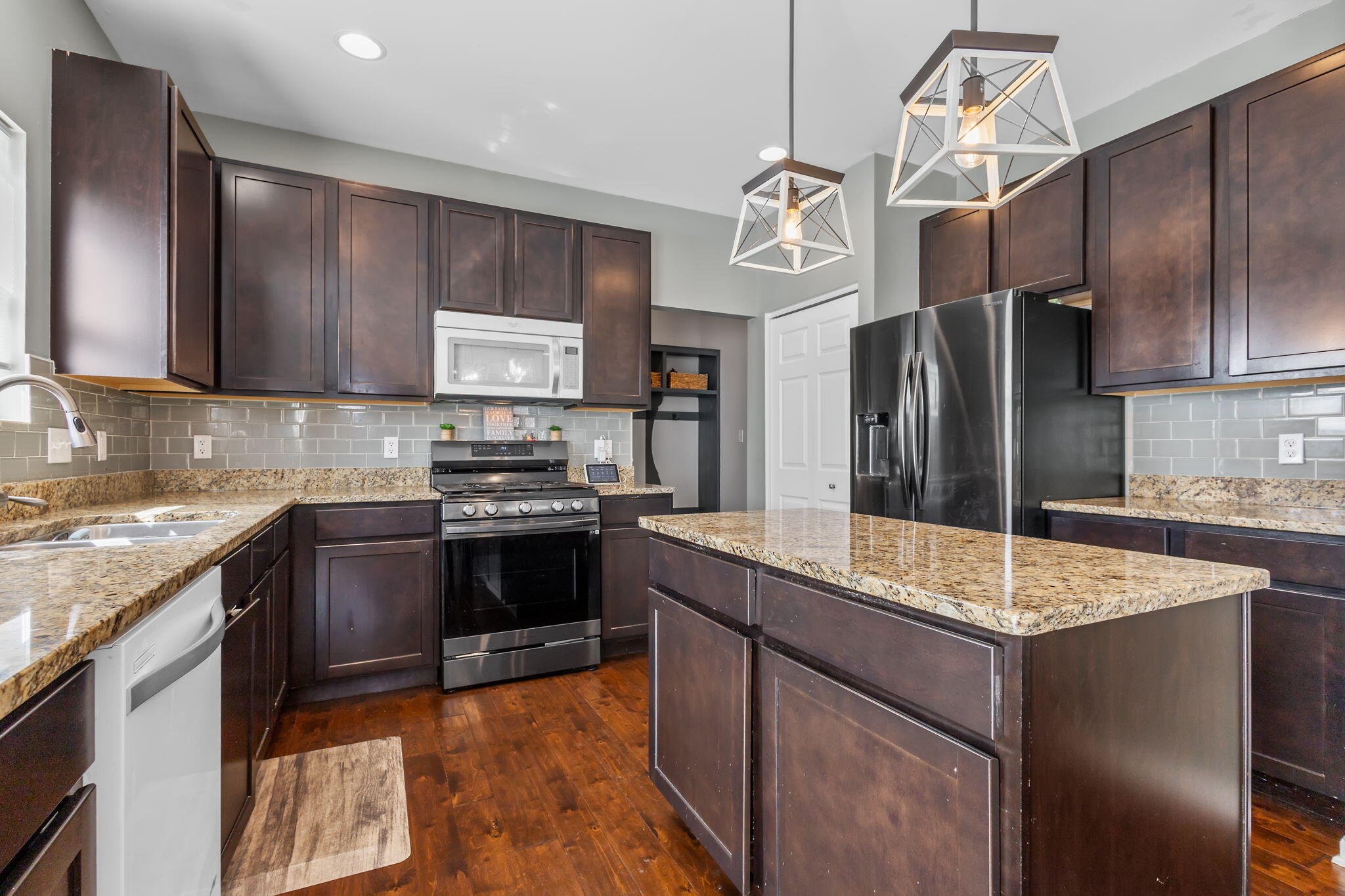 12938 Hayes Street Crown Point, IN 46307 - Photo 9 of 32 a kitchen with granite countertop a sink cabinets and stainless steel appliances
