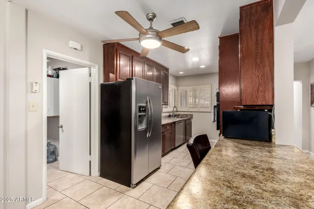 a kitchen with kitchen island granite countertop stainless steel appliances cabinets a sink and a counter top space