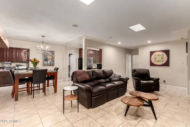 a living room with furniture and a dining table with kitchen view