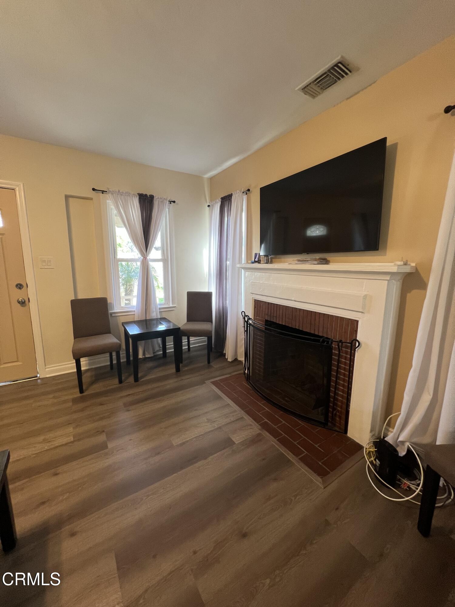 7618 Summitrose Street Tujunga, CA 91042 - Photo 6 of 15 a living room with furniture a flat screen tv and a fireplace