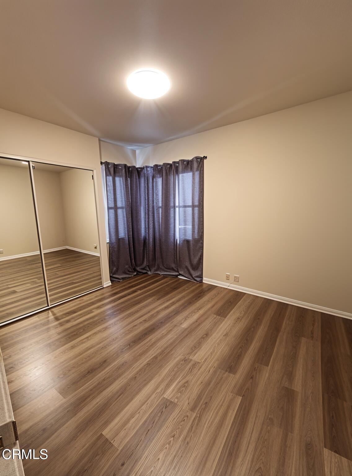 7618 Summitrose Street Tujunga, CA 91042 - Photo 9 of 15 a view of an empty room with wooden floor and a window