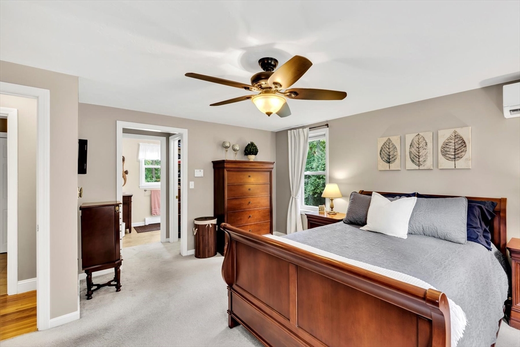 19 Drew Lane Mashpee, MA 02649 - Photo 24 of 42 a bedroom with a bed and a chandelier