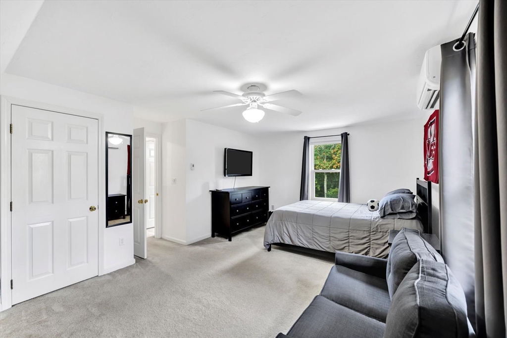 19 Drew Lane Mashpee, MA 02649 - Photo 36 of 42 a bedroom with a bed couches and a flat tv screen