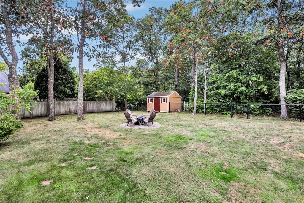 19 Drew Lane Mashpee, MA 02649 - Photo 5 of 42 a backyard of a house with table and chairs