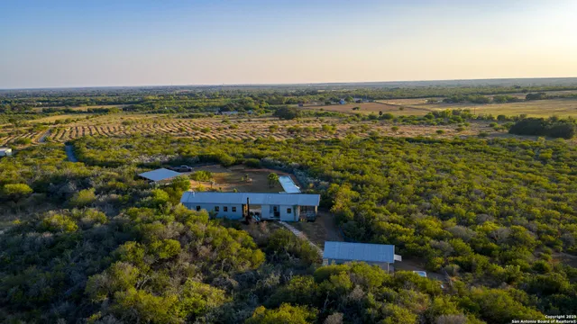 a backyard of a house with yard table and chairs