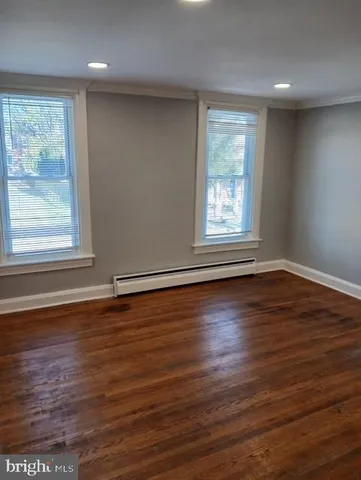 a view of an empty room with wooden floor