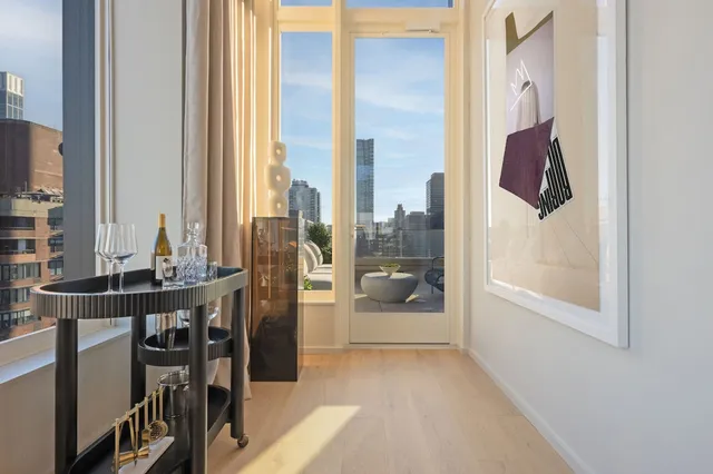 a living room with furniture a large window and wooden floor