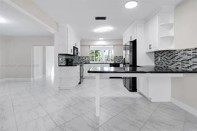a kitchen with stainless steel appliances kitchen island granite countertop a sink and cabinets