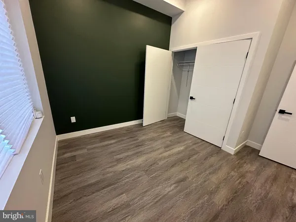 an empty room with wooden floor and entrance
