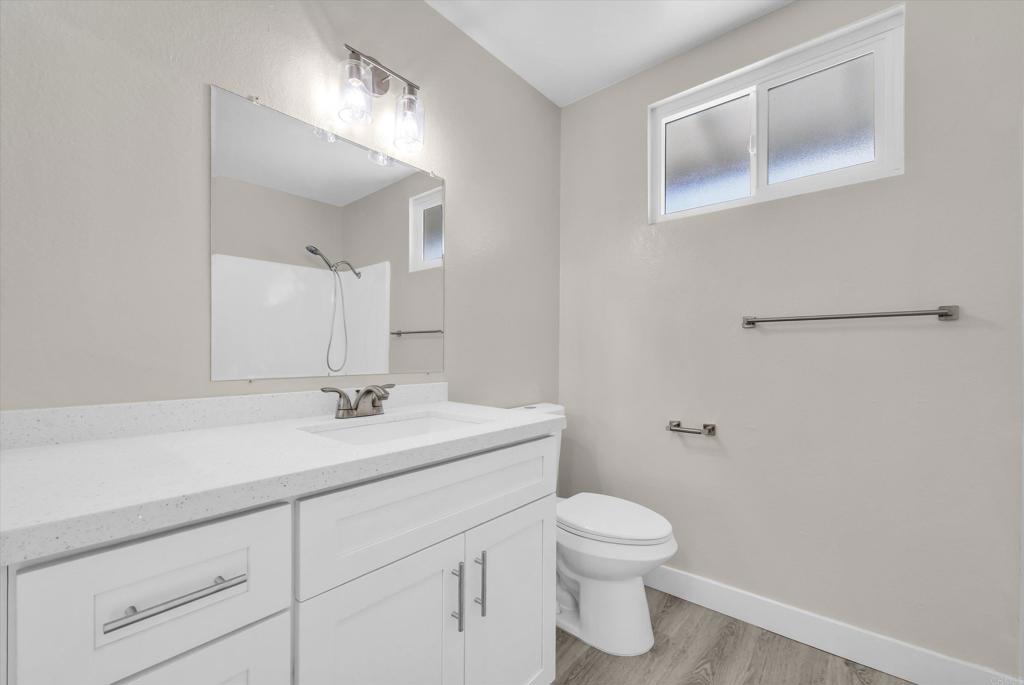 547 North Fillmore Avenue Rialto, CA 92376 - Photo 16 of 30 a bathroom with a toilet a sink and mirror