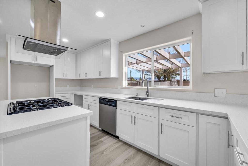 547 North Fillmore Avenue Rialto, CA 92376 - Photo 2 of 30 a kitchen with white cabinets a sink stove and window