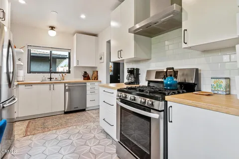 a kitchen with stainless steel appliances a stove a sink and a microwave