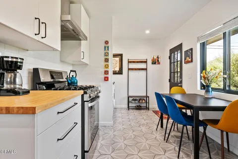 a kitchen with stainless steel appliances kitchen island granite countertop a table and chairs in it