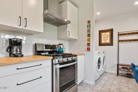 a kitchen with stainless steel appliances granite countertop a stove a sink and a white cabinets