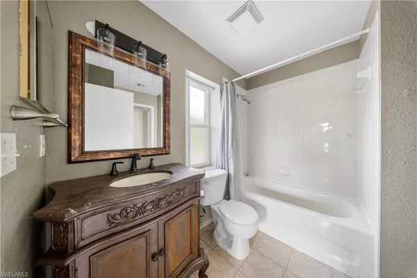 a bathroom with a granite countertop sink mirror vanity and toilet