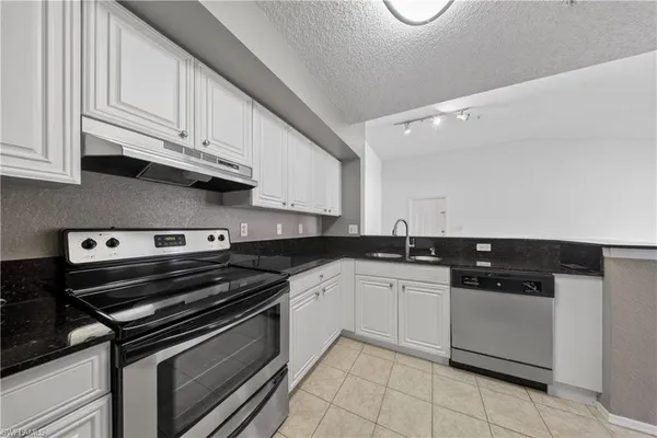a kitchen with stainless steel appliances granite countertop a sink and cabinets