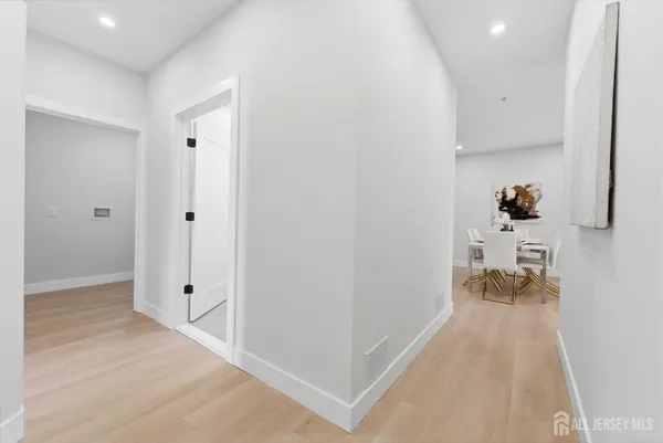 a view of a hallway with wooden floor and a living room