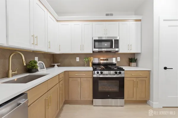 a kitchen with white cabinets and stainless steel appliances