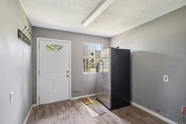 a view of an empty room with closet and a window