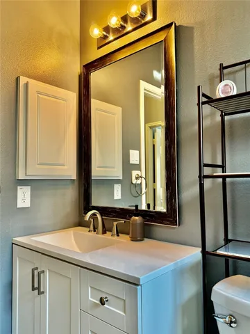 a bathroom with a toilet sink and mirror