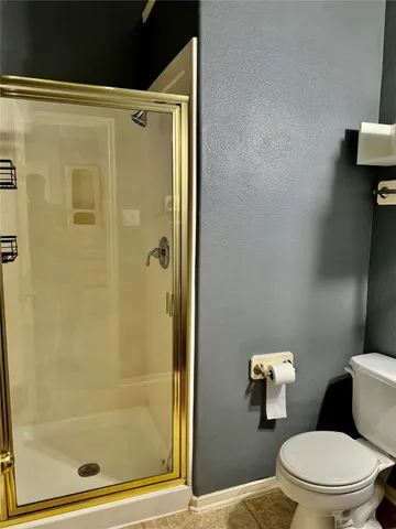 an empty room with wooden floor chandelier and windows