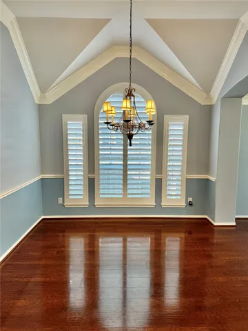 a view of a room with wooden floor and a window