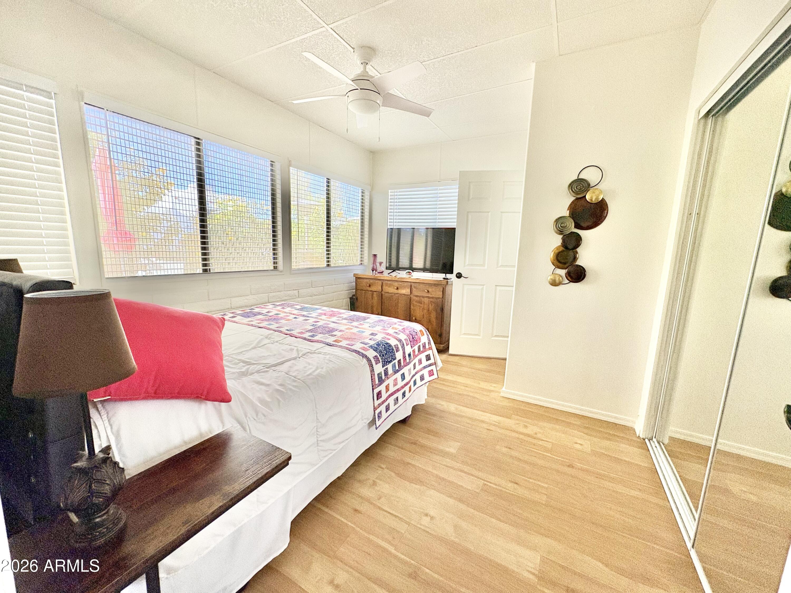 111 South Greenfield Road, Unit 589 Mesa, AZ 85206 - Photo 10 of 54 a bedroom with a large bed and a chandelier