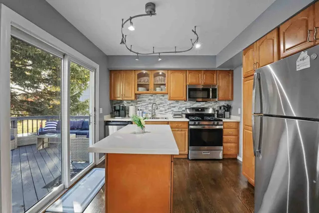 a kitchen with stainless steel appliances granite countertop a refrigerator a stove top oven a sink and dishwasher