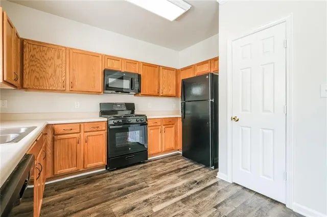 a kitchen with granite countertop a refrigerator stove top oven and sink