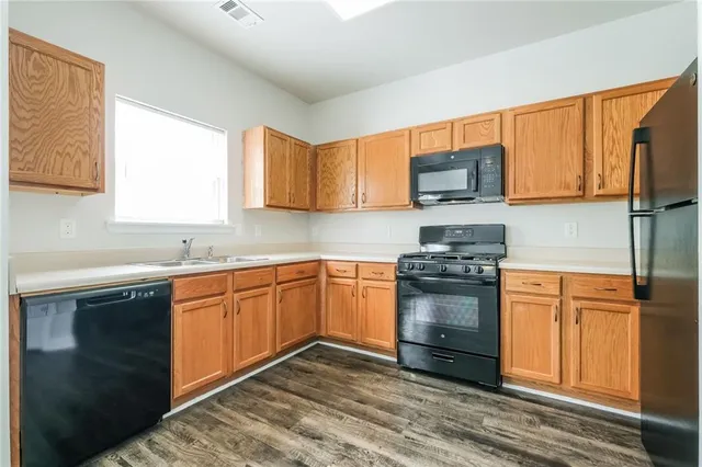 a kitchen with stainless steel appliances granite countertop a stove a sink and a microwave