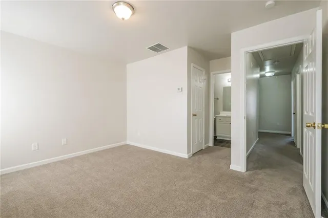 an empty room with closet and mirror