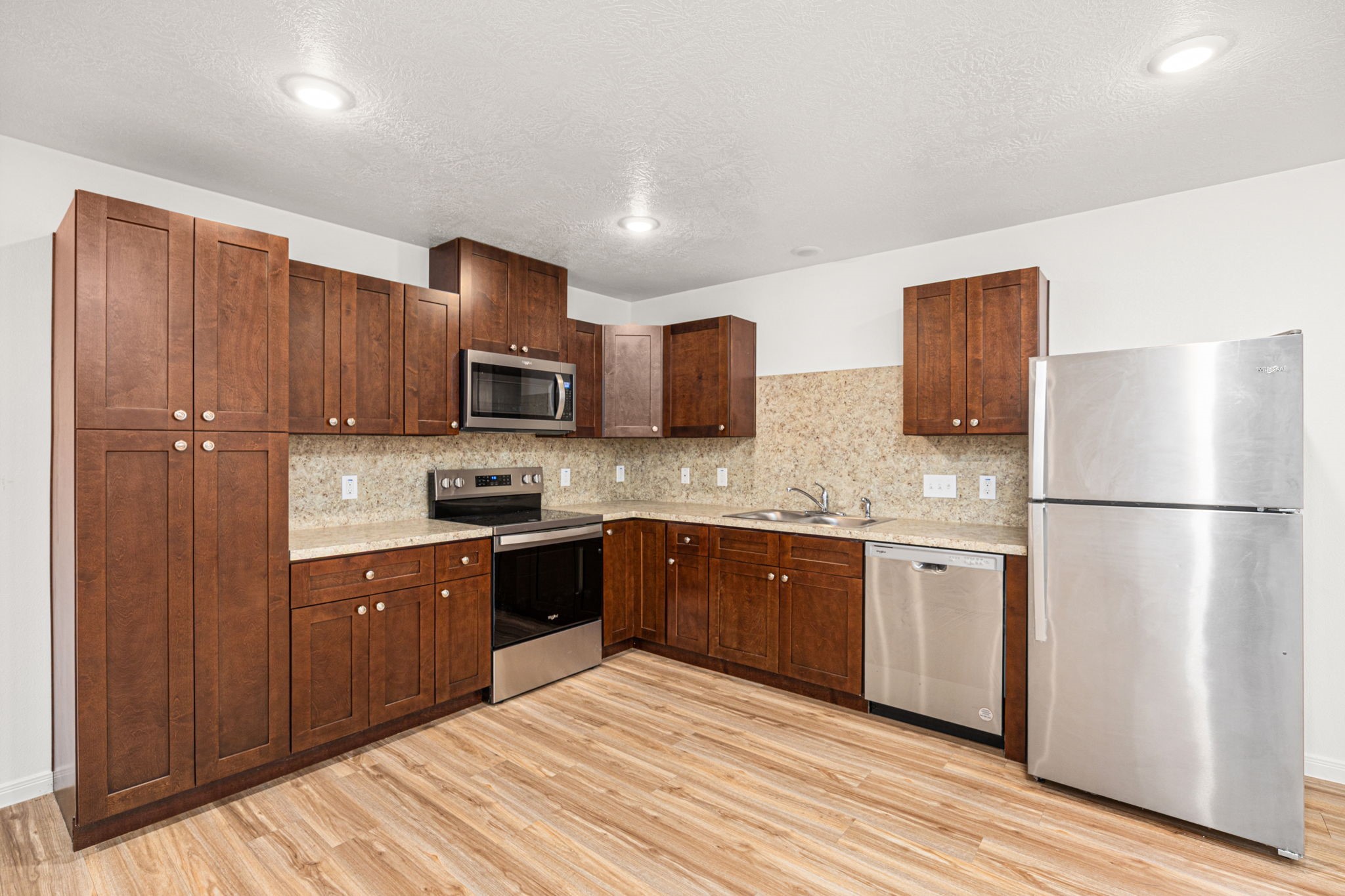23507 Prairie Bird Drive Spring, TX 77373 - Photo 11 of 30 a kitchen with stainless steel appliances granite countertop a refrigerator stove a sink dishwasher and wooden cabinets with wooden floor
