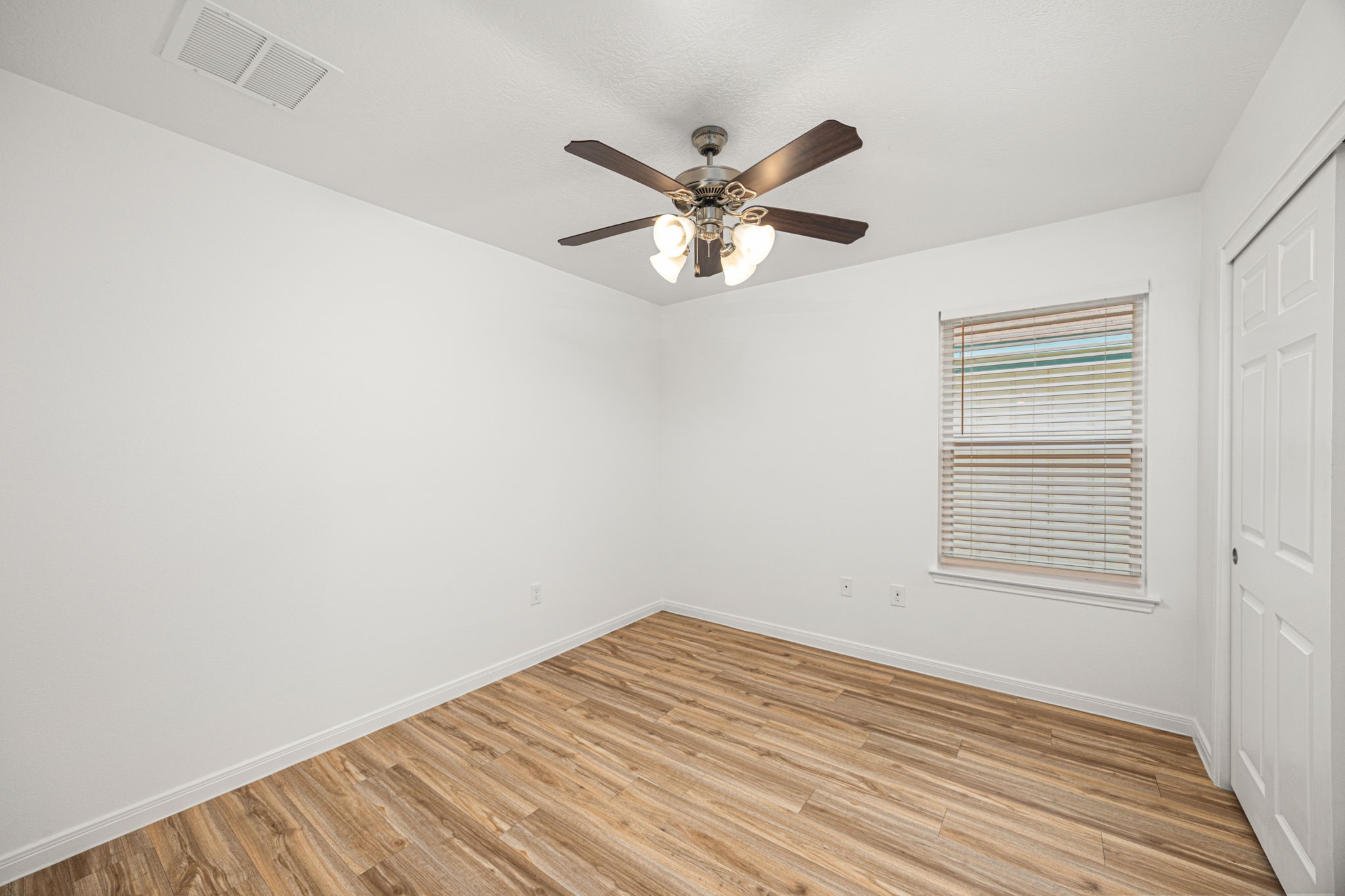 23507 Prairie Bird Drive Spring, TX 77373 - Photo 18 of 30 a view of a room with wooden floor and a ceiling fan