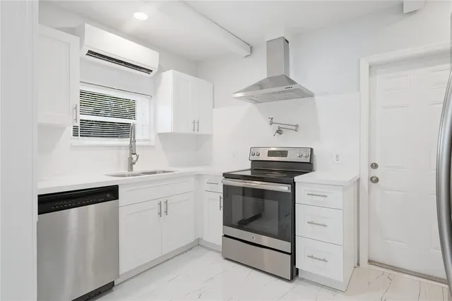 a kitchen with stainless steel appliances a stove a sink and a refrigerator