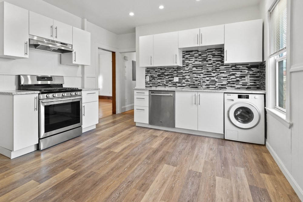 a kitchen with a stove and white cabinets