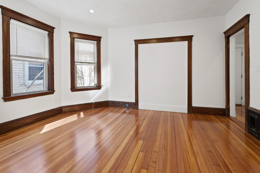 87 Bailey Street, Unit 2 Boston, MA 02124 - Photo 13 of 18 a view of an empty room with wooden floor and a window