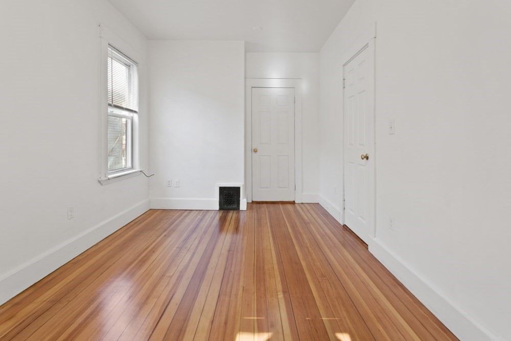 87 Bailey Street, Unit 2 Boston, MA 02124 - Photo 15 of 18 a view of an empty room with wooden floor and a window
