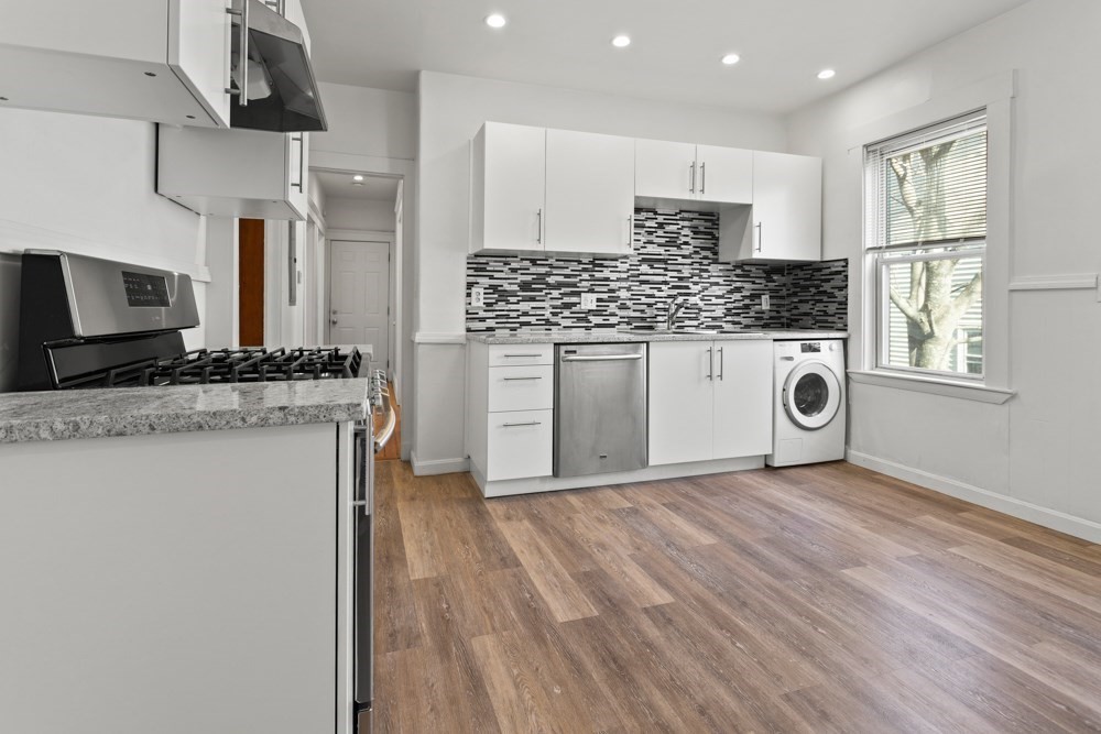 87 Bailey Street, Unit 2 Boston, MA 02124 - Photo 2 of 18 a kitchen with stainless steel appliances granite countertop a stove a sink and a microwave