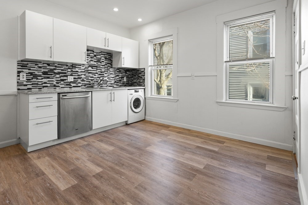 87 Bailey Street, Unit 2 Boston, MA 02124 - Photo 4 of 18 a kitchen with granite countertop white cabinets and white appliances