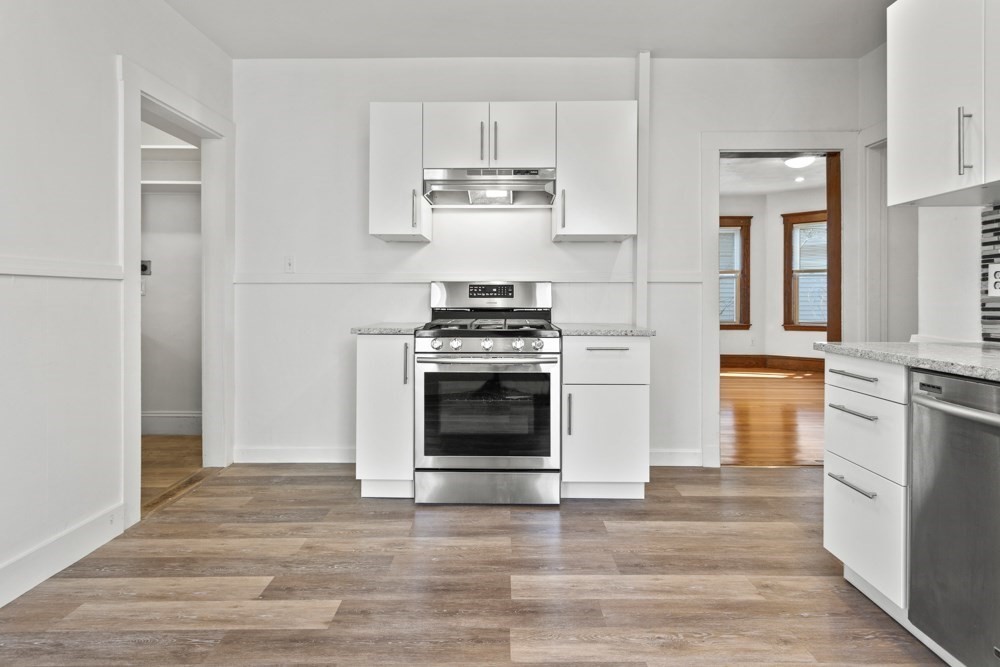 87 Bailey Street, Unit 2 Boston, MA 02124 - Photo 6 of 18 a kitchen with white cabinets and stainless steel appliances
