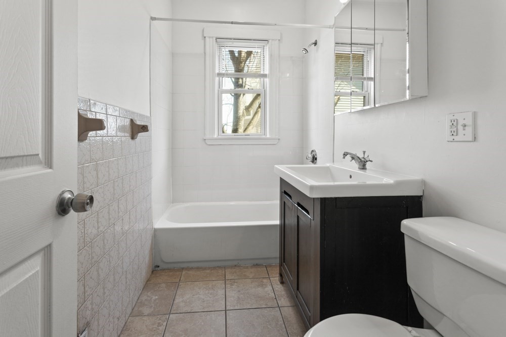 87 Bailey Street, Unit 2 Boston, MA 02124 - Photo 7 of 18 a bathroom with a sink a toilet and shower