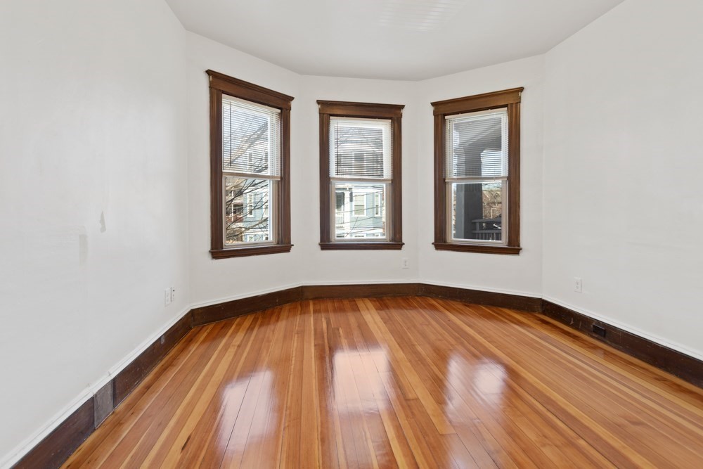 87 Bailey Street, Unit 2 Boston, MA 02124 - Photo 8 of 18 an empty room with wooden floor and windows