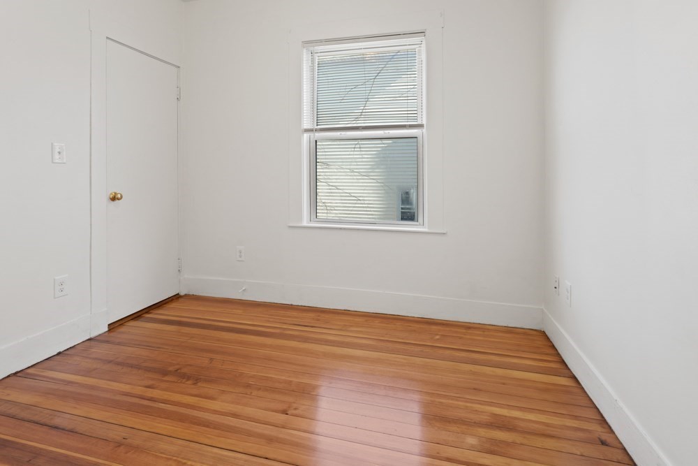 87 Bailey Street, Unit 2 Boston, MA 02124 - Photo 10 of 18 a view of an empty room with wooden floor and a window