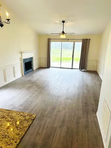 a view of an empty room with a fireplace and a window